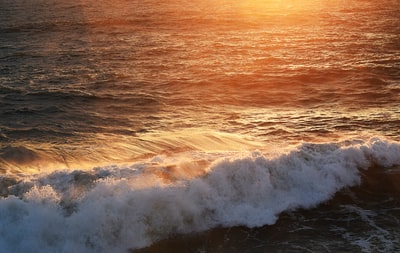 在日落海浪撞在岸上
